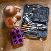 Bebe petite fille en train de jouer avec des outils et un moule a gateau. Cuisine mecanique. Outils. Dans l'atelier de son papa.