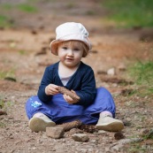 Bebe. Petite fille enfant dans la foret en train de jouer avec des pommes de pin. Dans les Cevennes (Mont AIgoual).