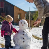 Petite fille et bonhomme de neige. En montagne dans les Cévennes (l'Esperou, proche du Mont Aigoual). Avce son grand pere.