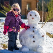 Petite fille et bonhomme de neige. En montagne dans les Cévennes (l'Esperou, proche du Mont Aigoual).