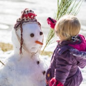 Petite fille et bonhomme de neige. En montagne dans les Cévennes (l'Esperou, proche du Mont Aigoual).