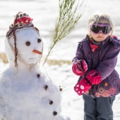 Petite fille et bonhomme de neige. En montagne dans les Cévennes (l'Esperou, proche du Mont Aigoual).