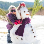 Petite fille et bonhomme de neige. En montagne dans les Cévennes (l'Esperou, proche du Mont Aigoual).