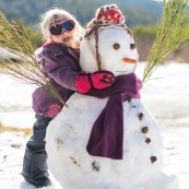 Petite fille et bonhomme de neige. En montagne dans les Cévennes (l'Esperou, proche du Mont Aigoual).