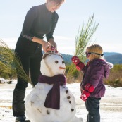 Petite fille et bonhomme de neige. En montagne dans les Cévennes (l'Esperou, proche du Mont Aigoual). Avec sa maman.