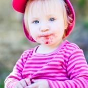 Bebe petite fille enfant en train de manger des cerises. Bouche sale.